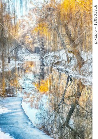Outstanding landscape in city park with snowy trees and beautiful reflection in frozen river. 120901816
