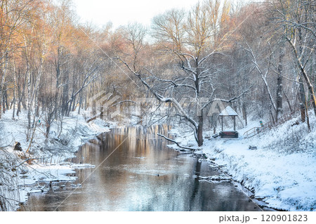 Outstanding landscape in city park with snowy trees and beautiful reflection in frozen river. 120901823