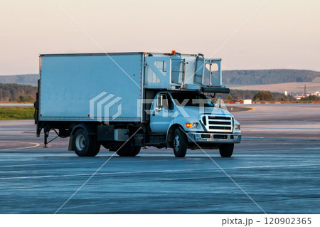 Truck delivering food to the airplane at the airport apron 120902365