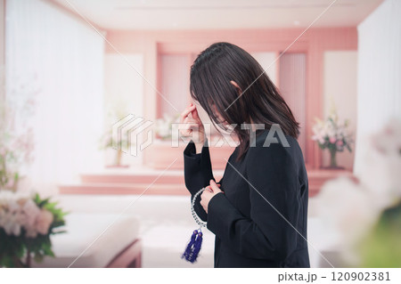 お葬式でお焼香をする女性の参列者 120902381