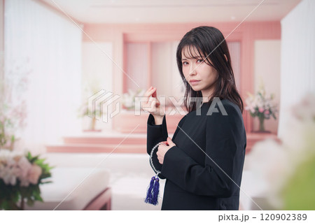 お葬式でお焼香をする女性の参列者 お葬式でお焼香をする女性の参列者 120902389