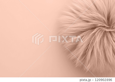 Closeup view of a fuzzy mocha mousse beige ball on a matching light backdrop with cope space. Modern trendy tone hue shade 120902896