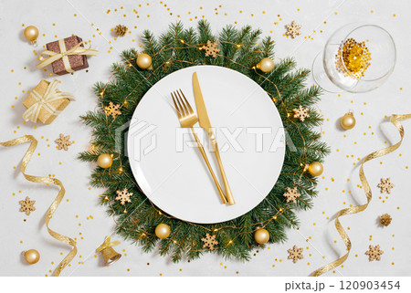 Christmas golden table setting with gold decorations and cutlery on white background. Beautiful New Year serving. View from above. Christmas golden table setting with gold decorations and cutlery on white background. Beautiful New Year serving. View from above. 120903454