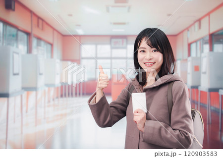 投票所で選挙の投票をする女性の有権者 120903583