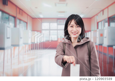 投票所で選挙の投票をする女性の有権者 120903589