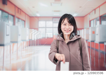 投票所で選挙の投票をする女性の有権者 120903596