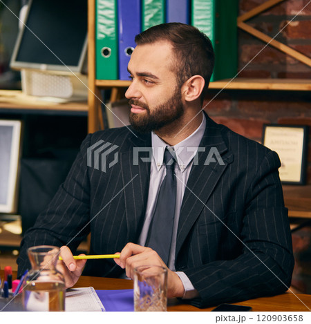 Bearded young businessman attentively listening to colleagues during business meeting, holding pen and taking notes. Bearded young businessman attentively listening to colleagues during business meeting, holding pen and taking notes. 120903658