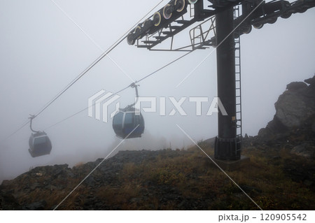 Gondola lifts in the mountains with a strong fog 120905542