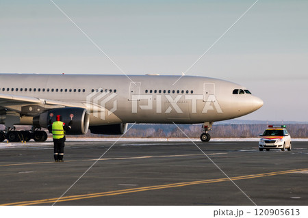 Passenger airplane is moving behind the follow me car. Airport ground crew meets aircraft 120905613