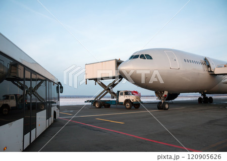 Airport bus near the passenger airplane on which the catering truck delivers food 120905626