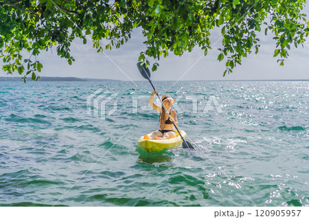 Woman kayaking on Bacalar Lake in Mexico. Adventure tourism in Quintana Roo, outdoor exploration, and water activities concept 120905957