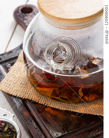 Glass teapot with tea on a brown board. Close-up. Glass teapot with tea on a brown board. Close-up. 120906001