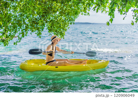 Woman kayaking on Bacalar Lake in Mexico. Adventure tourism in Quintana Roo, outdoor exploration, and water activities concept 120906049
