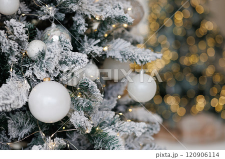 Close-up of a Christmas tree against a background of blurry garland lights. Close-up of a Christmas tree against a background of blurry garland lights. 120906114