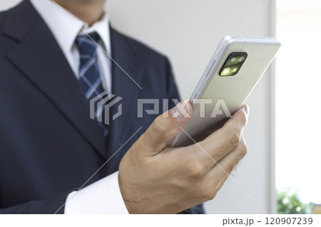 スーツを着てスマートフォンを持つ男の手（30代、日本人） 120907239