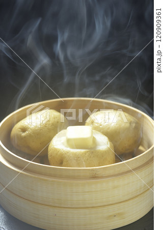 湯気が立ち昇る蒸籠でじゃがバター調理する 湯気が立ち昇る蒸籠でじゃがバター調理する 120909361