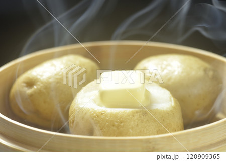 湯気が立ち昇る蒸籠でじゃがバター調理する 120909365