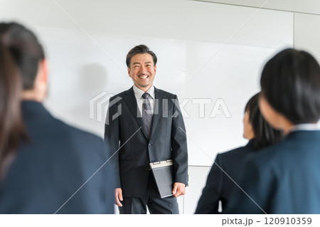 塾・セミナー・勉強会・説明会で先生・講師・教師から指導を受ける学生・女性 120910359
