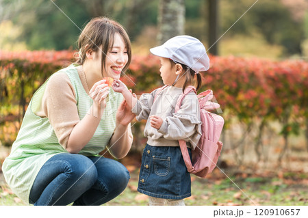 秋の公園を散歩・遠足する保育士の女性と園児（保育園・幼稚園保母・子供・幼児） 120910657
