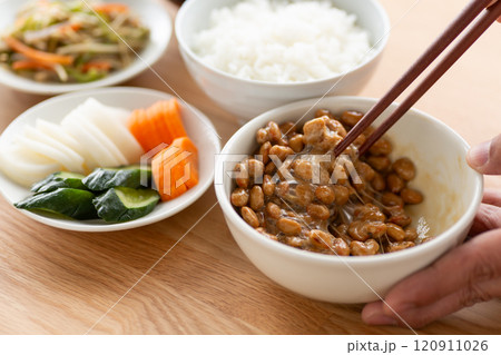 食卓に並ぶ和食と納豆を混ぜる手元 120911026