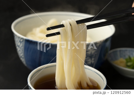 うどん 熱々のあつもりうどん 釜揚げうどんをつゆにつけて箸で持ち上げる うどん 熱々のあつもりうどん 釜揚げうどんをつゆにつけて箸で持ち上げる 120912560