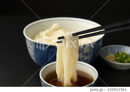 うどん 熱々のあつもりうどん 釜揚げうどんをつゆにつけて箸で持ち上げる うどん 熱々のあつもりうどん 釜揚げうどんをつゆにつけて箸で持ち上げる 120912561