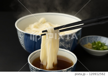 うどん 熱々のあつもりうどん 釜揚げうどんをつゆにつけて箸で持ち上げる うどん 熱々のあつもりうどん 釜揚げうどんをつゆにつけて箸で持ち上げる 120912562