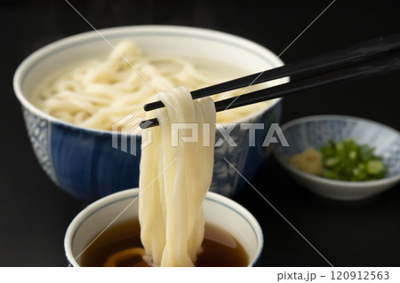 うどん　熱々のあつもりうどん　釜揚げうどんをつゆにつけて箸で持ち上げる 120912563