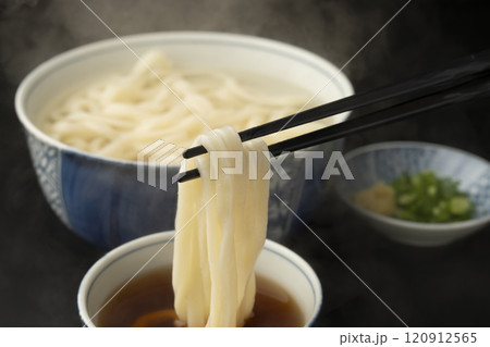 うどん 熱々のあつもりうどん 釜揚げうどんをつゆにつけて箸で持ち上げる うどん 熱々のあつもりうどん 釜揚げうどんをつゆにつけて箸で持ち上げる 120912565