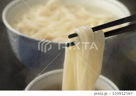 うどん 熱々のあつもりうどん 釜揚げうどんをつゆにつけて箸で持ち上げる うどん 熱々のあつもりうどん 釜揚げうどんをつゆにつけて箸で持ち上げる 120912567