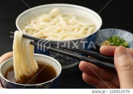 うどん 熱々のあつもりうどん 釜揚げうどんをつゆにつけて箸で持ち上げる うどん 熱々のあつもりうどん 釜揚げうどんをつゆにつけて箸で持ち上げる 120912570