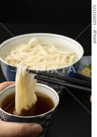 うどん 熱々のあつもりうどん 釜揚げうどんをつゆにつけて箸で持ち上げる うどん 熱々のあつもりうどん 釜揚げうどんをつゆにつけて箸で持ち上げる 120912572