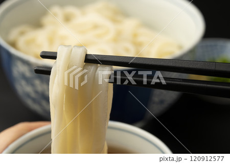 うどん 熱々のあつもりうどん 釜揚げうどんをつゆにつけて箸で持ち上げる うどん 熱々のあつもりうどん 釜揚げうどんをつゆにつけて箸で持ち上げる 120912577