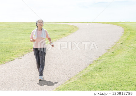 公園で散歩・ウォーキング中に深呼吸するシニア女性 120912789