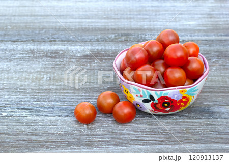 Red cherry tomatoes in a bowl with floral pattern. Red cherry tomatoes in a bowl with floral pattern. 120913137