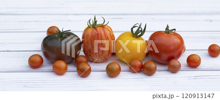 Variety of colorful tomatoes on the white wooden rustic table. Variety of colorful tomatoes on the white wooden rustic table. 120913147