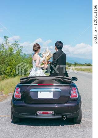 愛車とフォトウェディングを撮る新郎新婦（オープンカー） 120913166