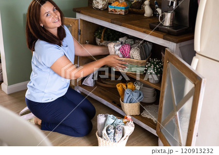 Housewife cleaning maintaining kitchen towels storage organizing retro rustic commode home interior Housewife cleaning maintaining kitchen towels storage organizing retro rustic commode home interior 120913232