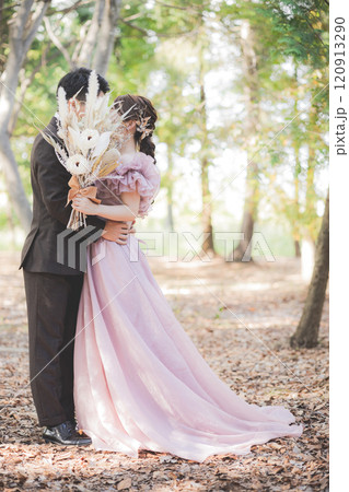 公園でウェディングフォトを撮るカラードレスを着たカップル(キス) 公園でウェディングフォトを撮るカラードレスを着たカップル(キス) 120913290
