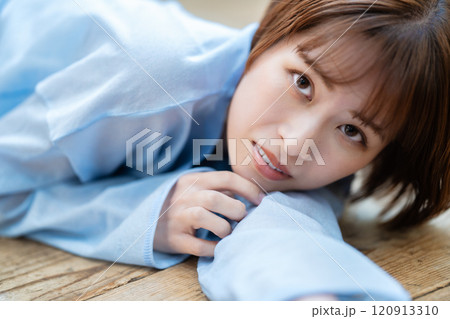 フローリングに寝転ぶショートボブの若い女性 フローリングに寝転ぶショートボブの若い女性 120913310