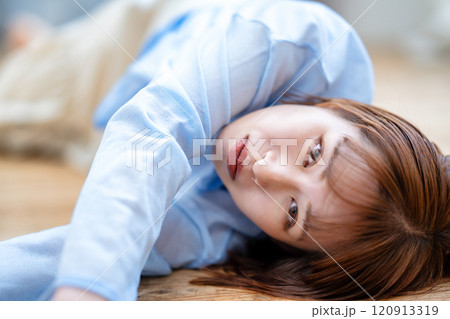 フローリングに寝転ぶショートボブの若い女性 フローリングに寝転ぶショートボブの若い女性 120913319