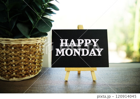 Happy Monday text on paper card with ealsel on wooden background 120914045