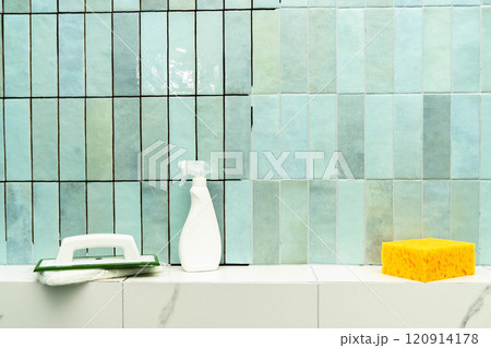 Applying epoxy grout and adhesive to ceramic tiles in a bright bathroom space. 120914178