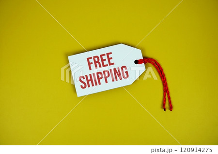 Free Shipping on price tag with wooden clothes hanger top view on yellow background Free Shipping on price tag with wooden clothes hanger top view on yellow background 120914275