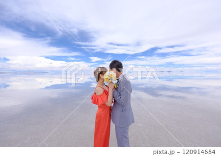 ウユニ塩湖｜花束で顔を隠してキスをする幻想的なウェディングフォト 120914684