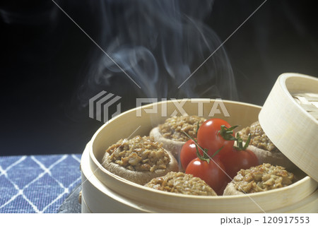 湯気の立ち昇る蒸籠で椎茸の肉詰めを調理する 120917553