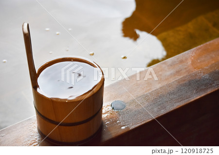 湯気が立ち昇る檜の露天風呂に置かれた檜の手桶 120918725