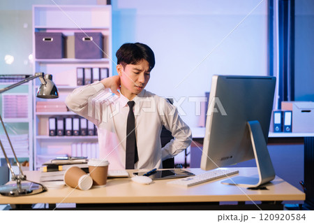 Overtime work concept, Handsome asian business man working overtime sitting at desk using computer and doing overtime project 120920584