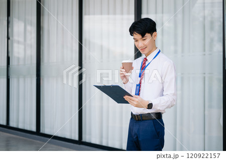 Young Asian businessman leader entrepreneur, professional manager holding digital tablet computer on the street in big city 120922157