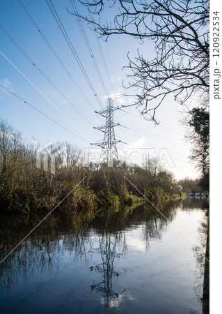 快晴の青い空の下のロンドン郊外のコルネ・バレーの運河脇に立つ大きな鉄塔 120922534